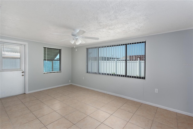 spare room with a textured ceiling, baseboards, ornamental molding, and ceiling fan