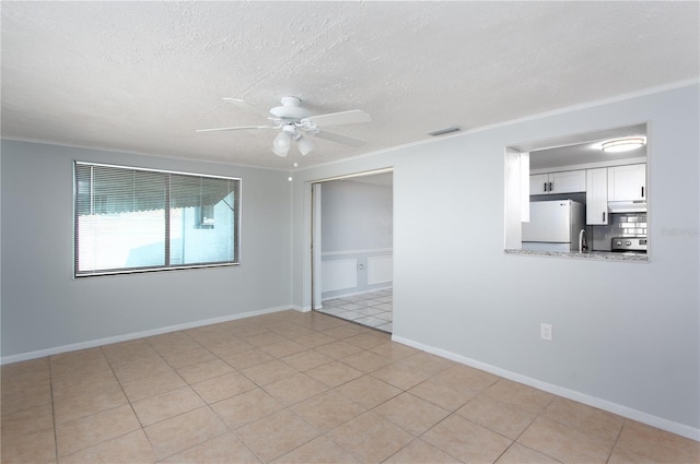 empty room featuring ornamental molding, visible vents, ceiling fan, and a textured ceiling