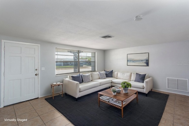 living room with light tile patterned flooring, baseboards, and visible vents