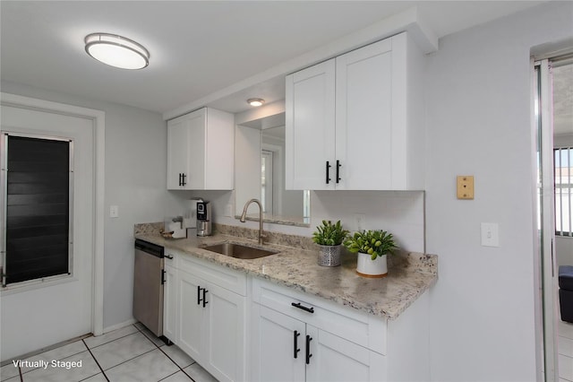 kitchen with stainless steel dishwasher, a sink, and white cabinetry