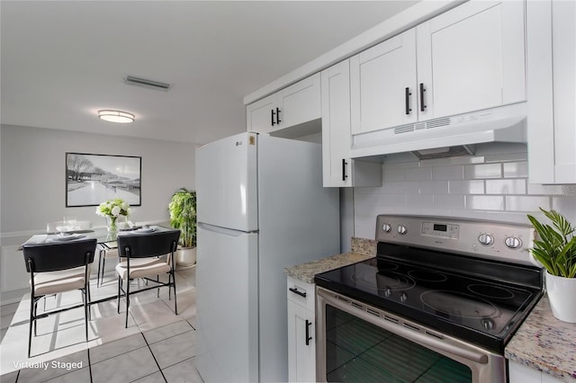 kitchen with freestanding refrigerator, white cabinetry, visible vents, under cabinet range hood, and stainless steel electric range