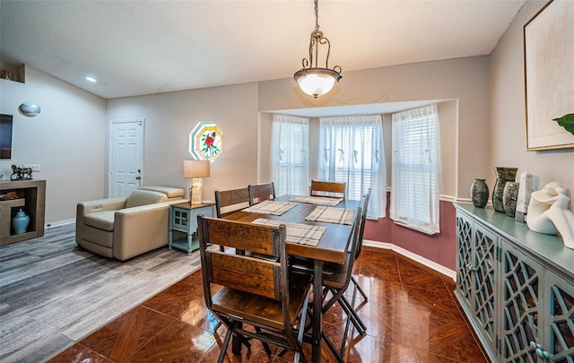 dining area with a textured ceiling, baseboards, and recessed lighting