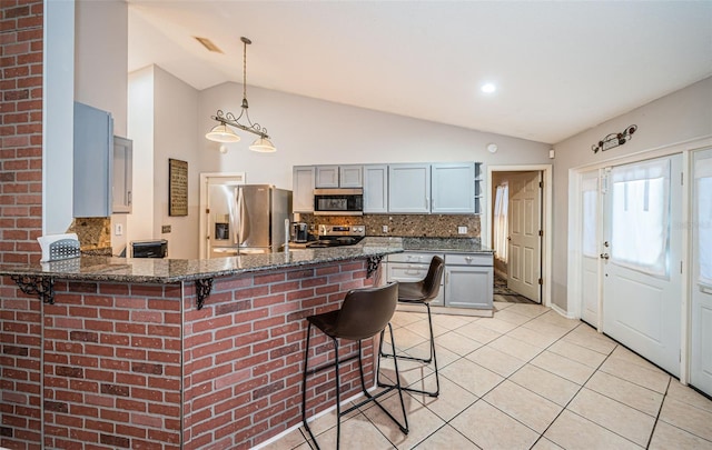 kitchen with backsplash, lofted ceiling, and stainless steel appliances