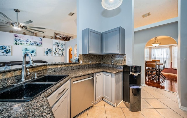kitchen featuring arched walkways, stainless steel dishwasher, a sink, and visible vents