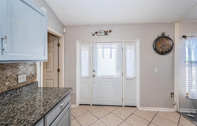 entryway featuring baseboards and light tile patterned flooring