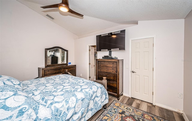 bedroom with lofted ceiling, a textured ceiling, visible vents, ceiling fan, and wood finished floors