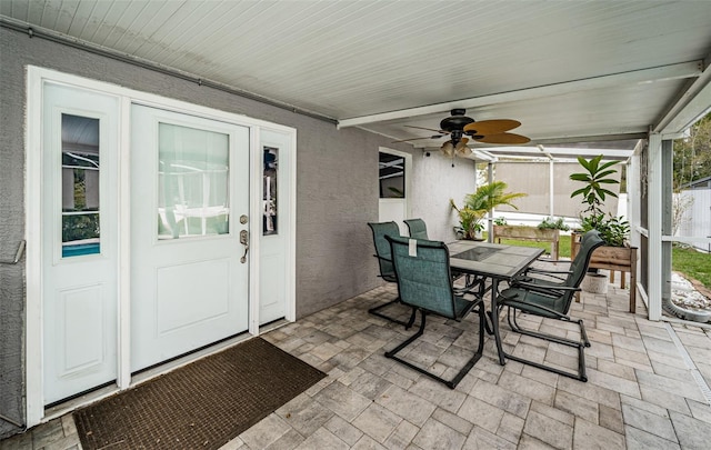 sunroom / solarium featuring outdoor dining space and a ceiling fan
