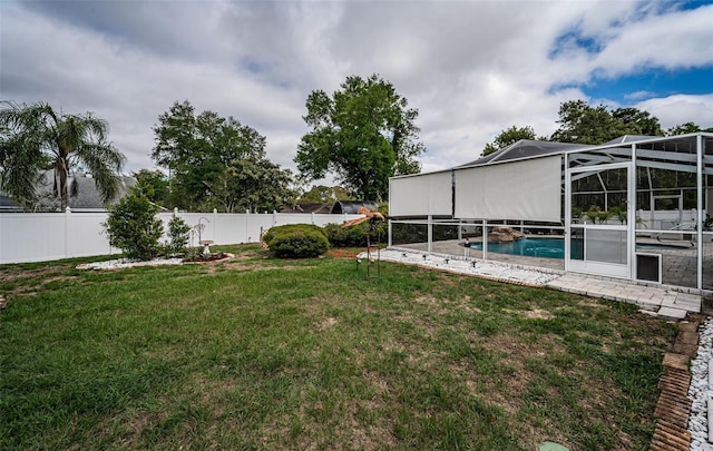 view of yard featuring a fenced in pool, a fenced backyard, and a lanai