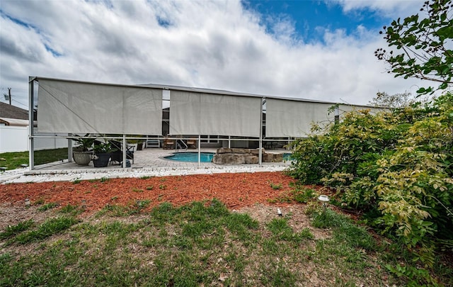 rear view of house with fence, a fenced in pool, and a patio