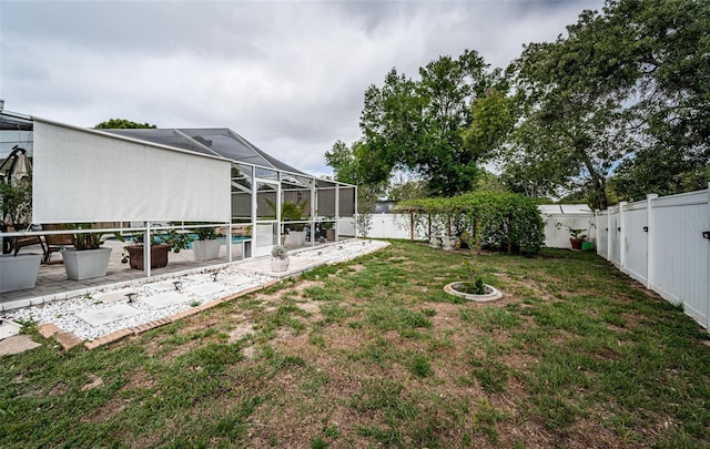 view of yard featuring a patio area, a fenced backyard, a swimming pool, and a lanai
