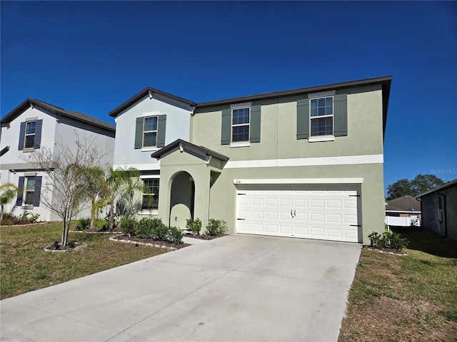 traditional-style house featuring driveway, stucco siding, an attached garage, and a front lawn