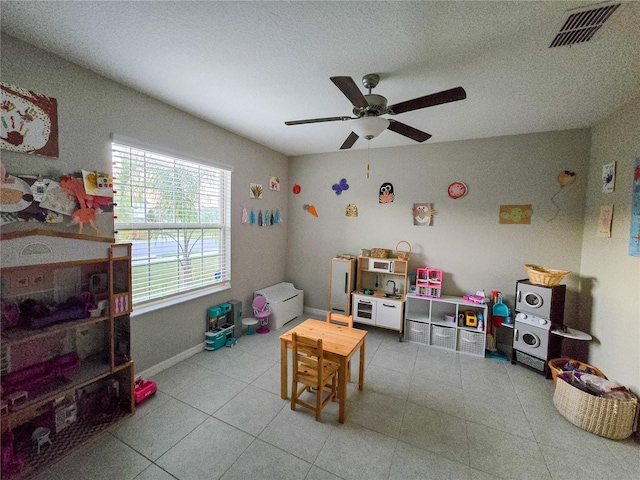 game room featuring visible vents, baseboards, a ceiling fan, and a textured ceiling