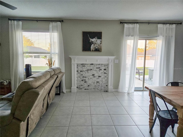 living area featuring light tile patterned floors, baseboards, and plenty of natural light