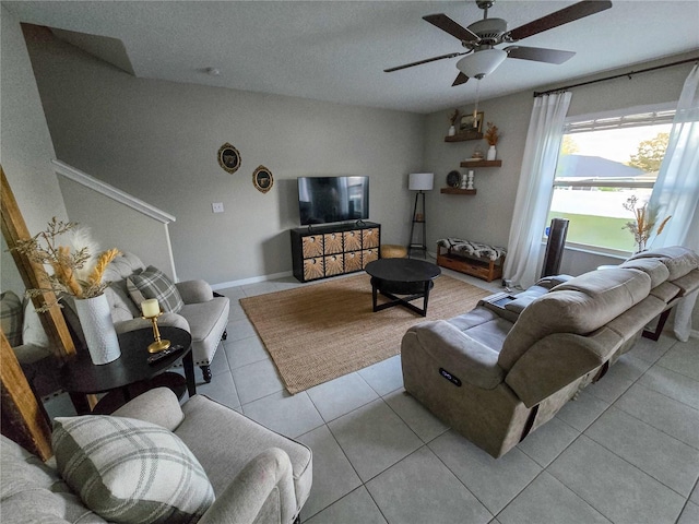 living area with tile patterned flooring, baseboards, and ceiling fan