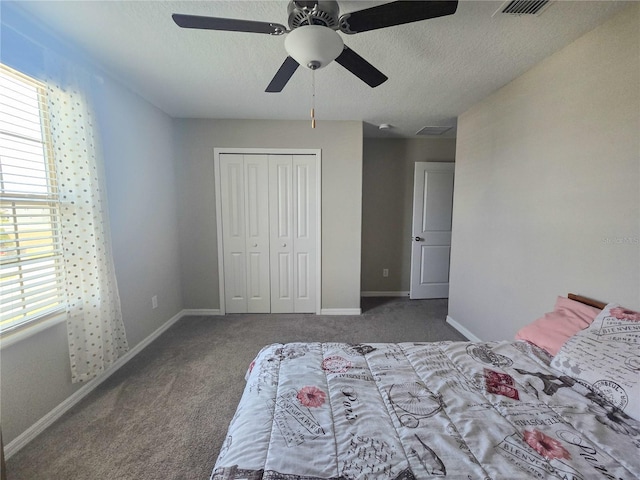 carpeted bedroom featuring a closet, ceiling fan, visible vents, and a textured ceiling