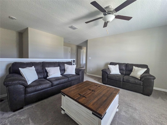 carpeted living room featuring visible vents, baseboards, a ceiling fan, and a textured ceiling