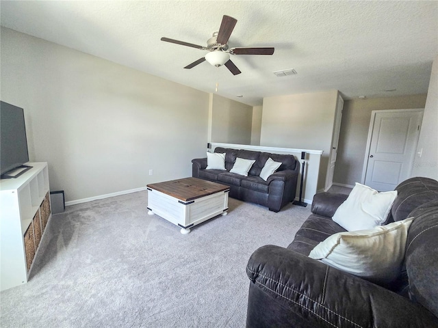 living room with ceiling fan, a textured ceiling, visible vents, carpet floors, and baseboards
