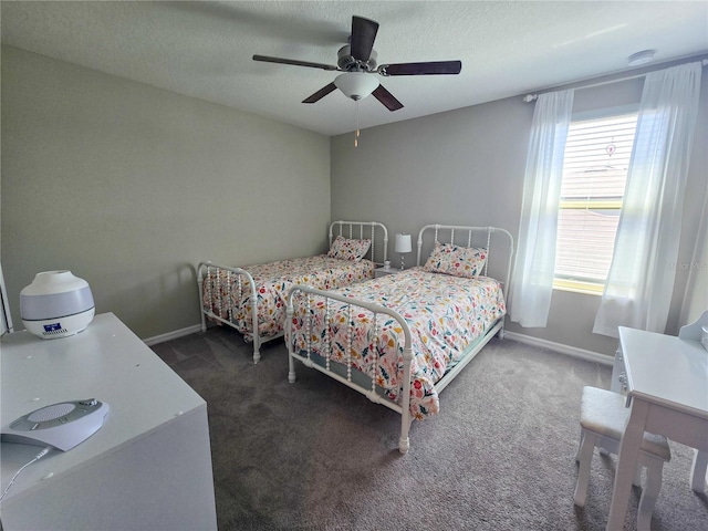 carpeted bedroom with a textured ceiling, baseboards, and a ceiling fan