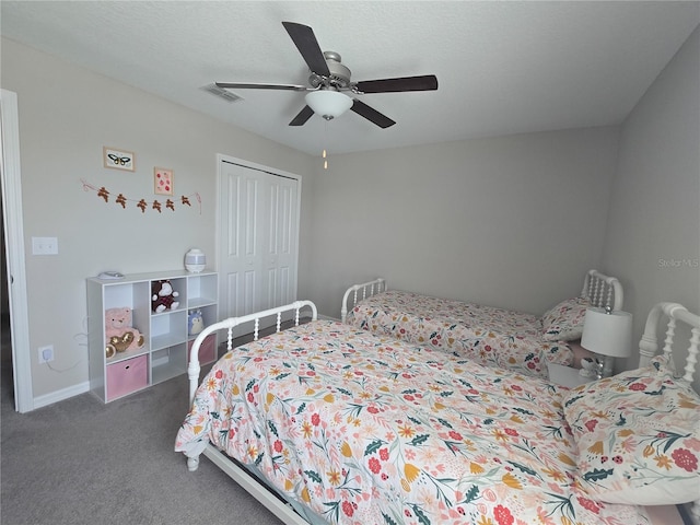 carpeted bedroom featuring a closet, a ceiling fan, and visible vents