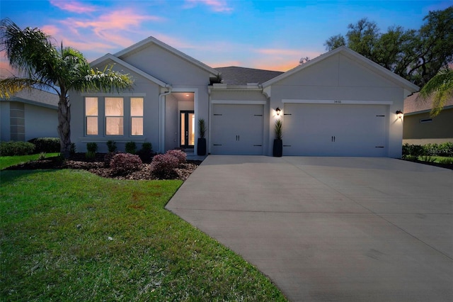 single story home with a garage, a yard, stucco siding, and concrete driveway