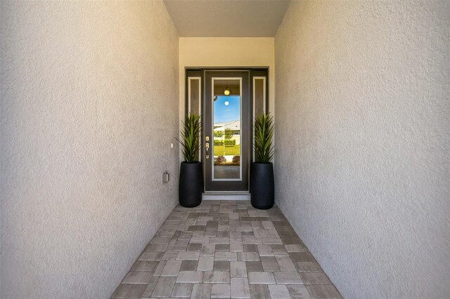 entrance to property featuring stucco siding