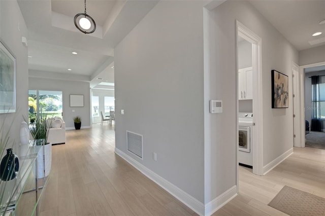 hall featuring visible vents, baseboards, recessed lighting, light wood finished floors, and washer / dryer