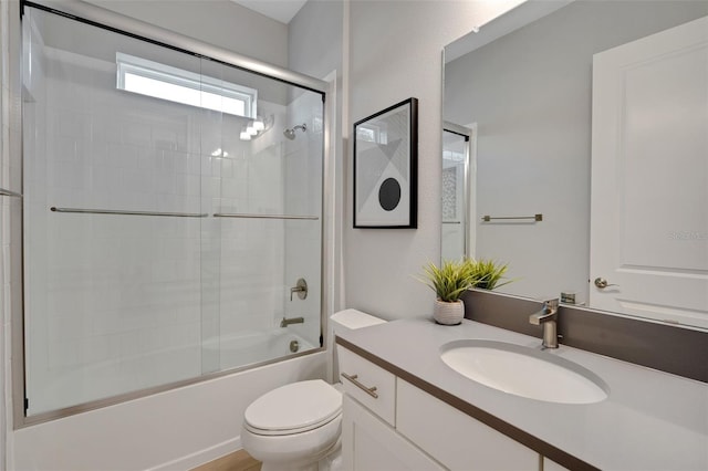 bathroom featuring toilet, vanity, and bath / shower combo with glass door