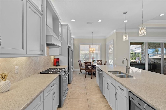 kitchen featuring hanging light fixtures, baseboards, a sink, stainless steel appliances, and decorative backsplash