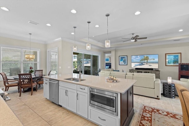 kitchen with a sink, appliances with stainless steel finishes, light tile patterned flooring, and crown molding