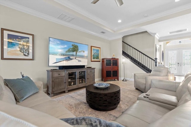 living room featuring baseboards, ornamental molding, visible vents, and stairs