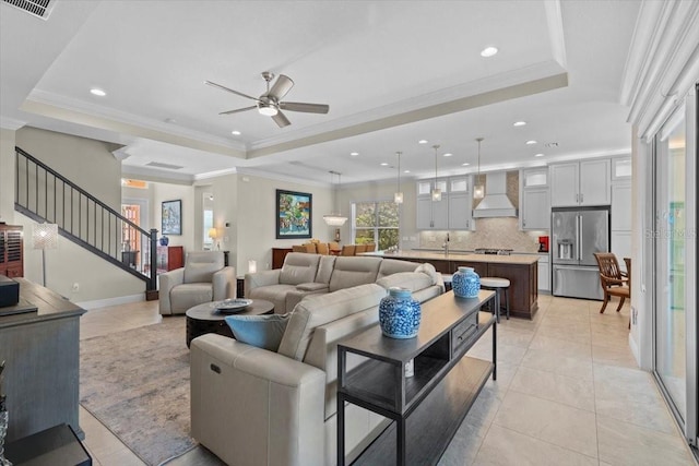 living area with recessed lighting, stairway, ceiling fan, and a raised ceiling