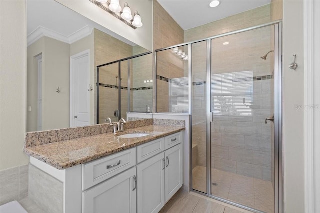 bathroom featuring a stall shower, vanity, and ornamental molding