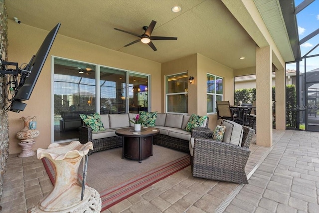 view of patio / terrace with ceiling fan, glass enclosure, and an outdoor hangout area
