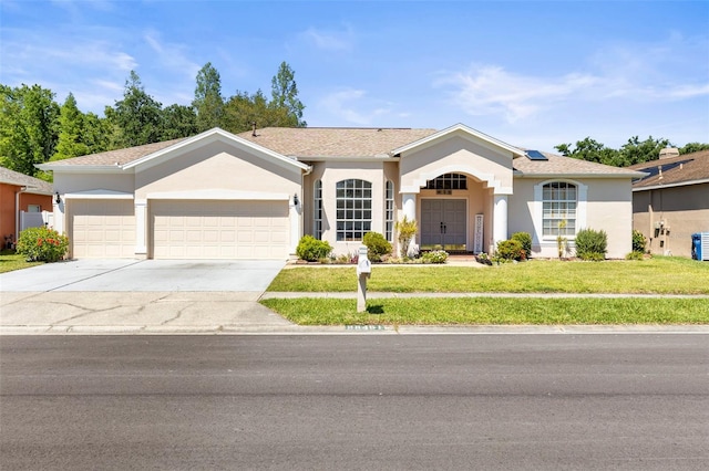 single story home featuring an attached garage, concrete driveway, a front yard, and stucco siding