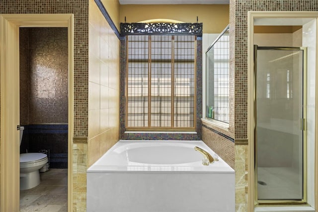 full bath featuring toilet, a stall shower, and a garden tub