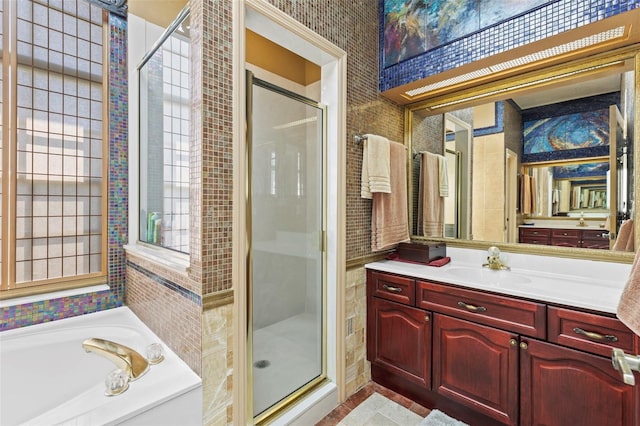 bathroom featuring vanity, a bath, and a stall shower