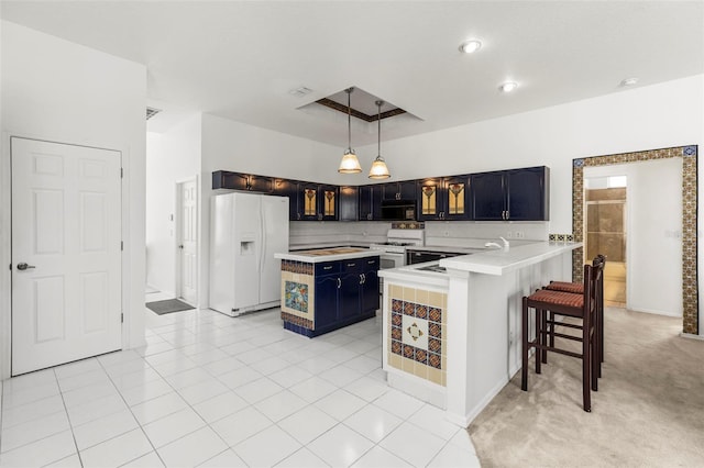 kitchen featuring white appliances, a peninsula, blue cabinets, a sink, and light countertops