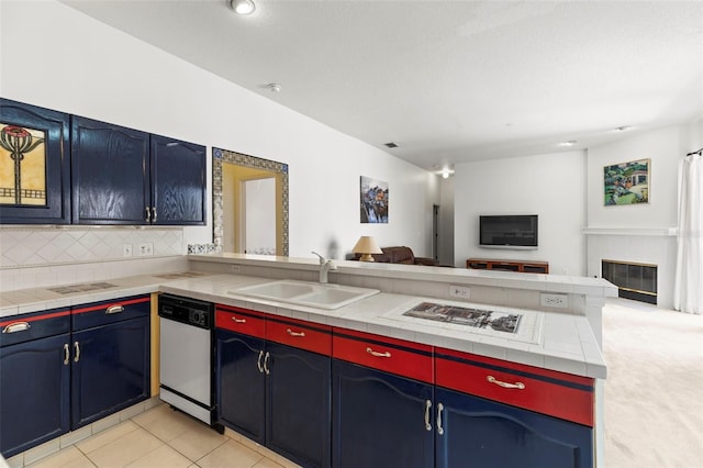 kitchen with a peninsula, tasteful backsplash, dishwasher, a sink, and open floor plan