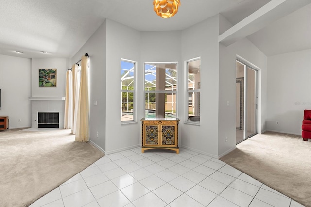 tiled entryway with baseboards, carpet flooring, and a fireplace