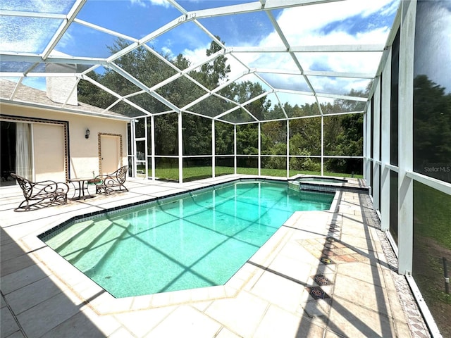view of swimming pool featuring a patio, a pool with connected hot tub, and glass enclosure