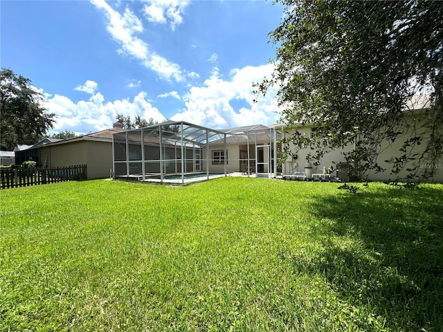 exterior space featuring an outdoor pool, glass enclosure, and fence