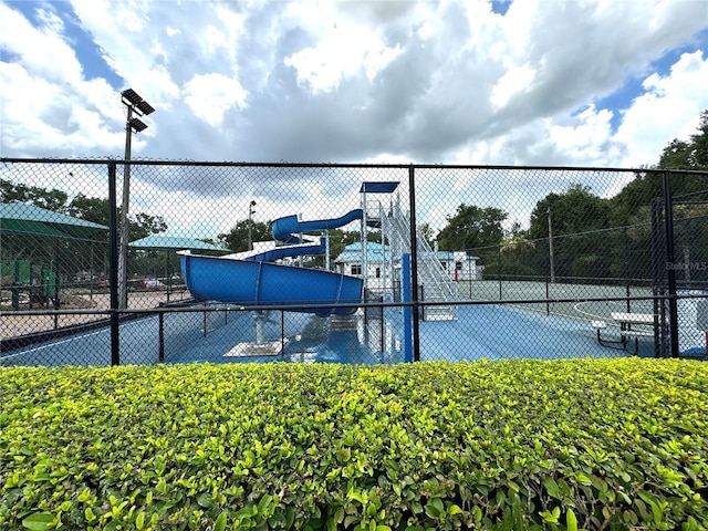 view of tennis court featuring fence