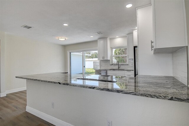 3841 Wahoo Dr SE, Saint Petersburg, FL 33705 - kitchen with tasteful backsplash, white cabinetry, stone countertops, appliances with stainless steel finishes, and a sink