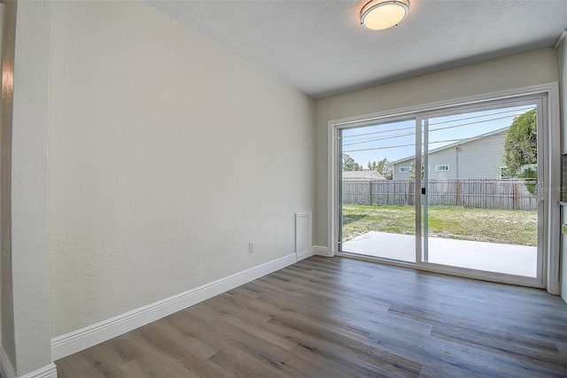 3841 Wahoo Dr SE, Saint Petersburg, FL 33705 - spare room with a textured wall, baseboards, wood finished floors, and a textured ceiling