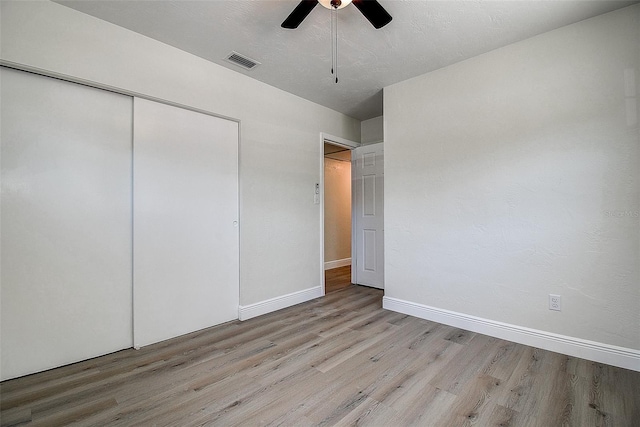 3841 Wahoo Dr SE, Saint Petersburg, FL 33705 - unfurnished bedroom with light wood-style flooring, a closet, a ceiling fan, visible vents, and baseboards