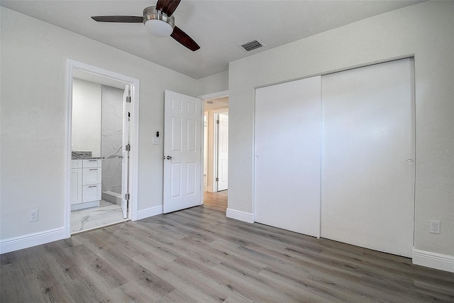 3841 Wahoo Dr SE, Saint Petersburg, FL 33705 - unfurnished bedroom featuring visible vents, connected bathroom, a closet, and wood finished floors