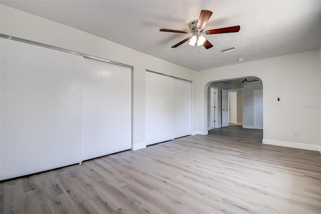 3841 Wahoo Dr SE, Saint Petersburg, FL 33705 - unfurnished bedroom with visible vents, baseboards, arched walkways, two closets, and wood finished floors