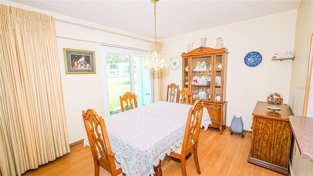 1655 S Highland Ave Unit F126, Clearwater, FL 33756 - dining area with baseboards, a notable chandelier, and light wood-style floors