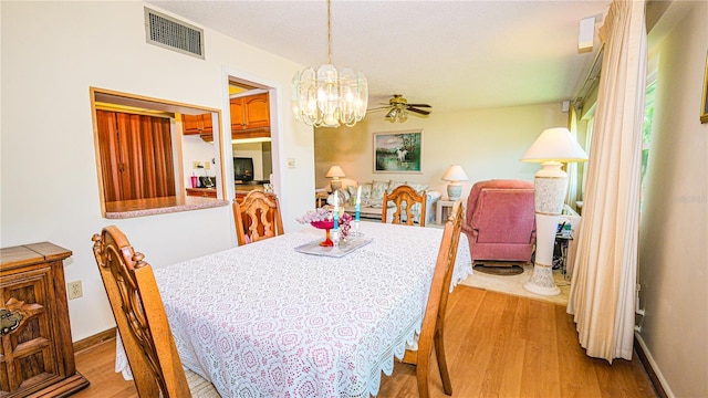 1655 S Highland Ave Unit F126, Clearwater, FL 33756 - dining area featuring visible vents, ceiling fan with notable chandelier, wood finished floors, and a fireplace