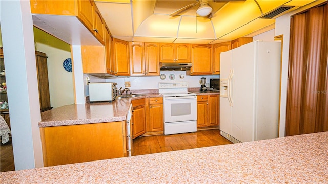 1655 S Highland Ave Unit F126, Clearwater, FL 33756 - kitchen with visible vents, a sink, light wood-type flooring, white appliances, and under cabinet range hood